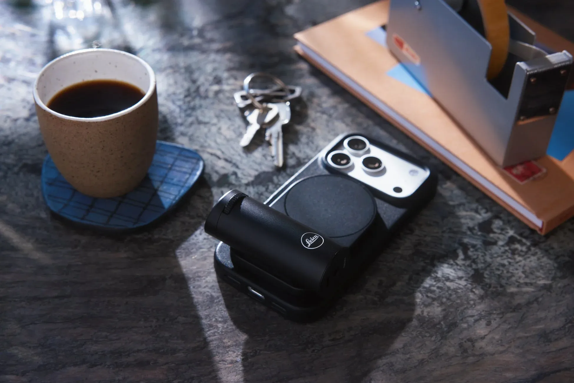 デスクに置かれたLeicaレンズ付きスマートフォンとケース