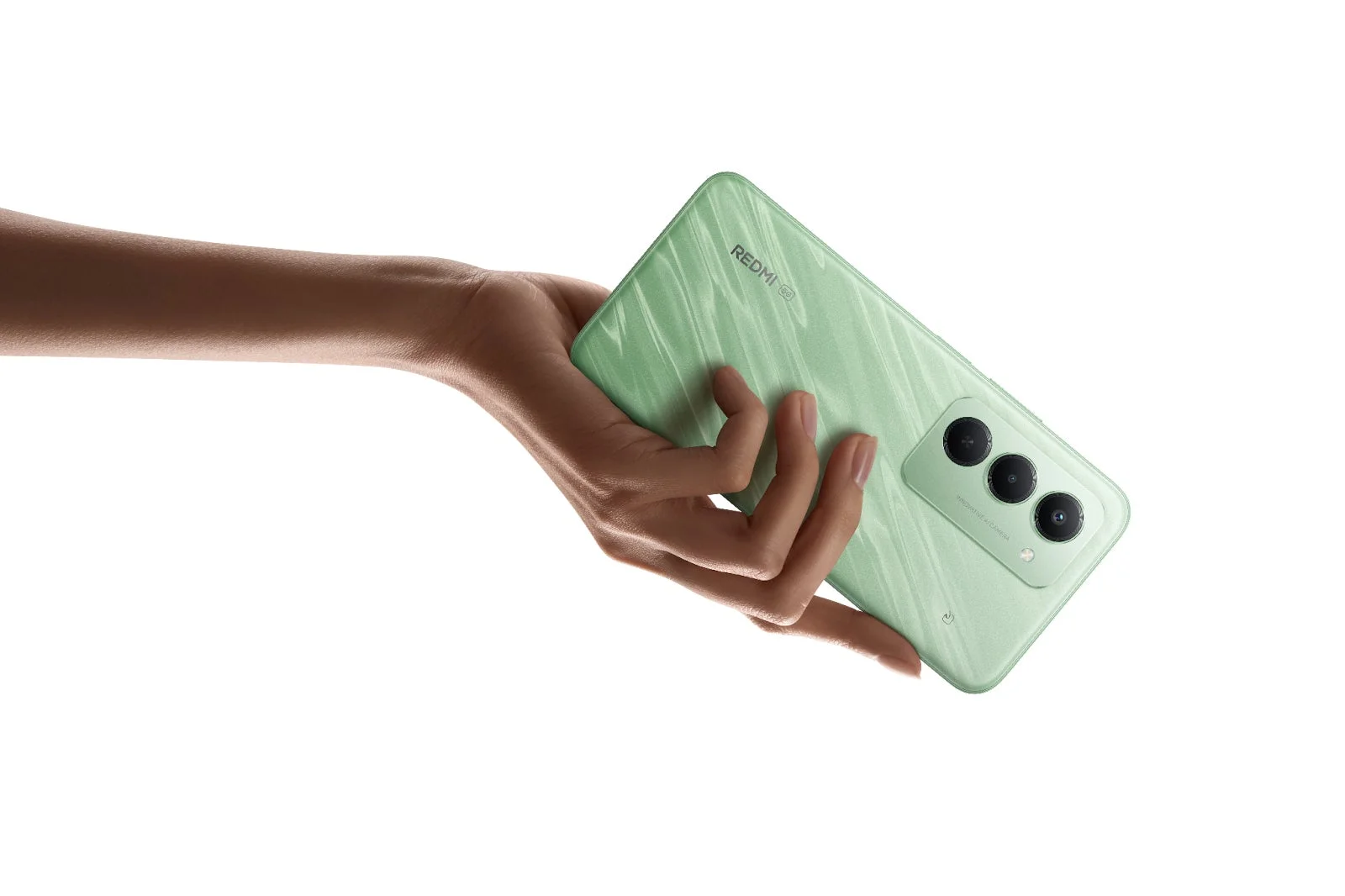 白い背景に、手が淡い緑色のRedmi 5Gスマートフォンを持っている画像です。スマートフォンの背面には、3つのカメラレンズと「INNOVATIVE AI CAMERA」の文字が見えます。